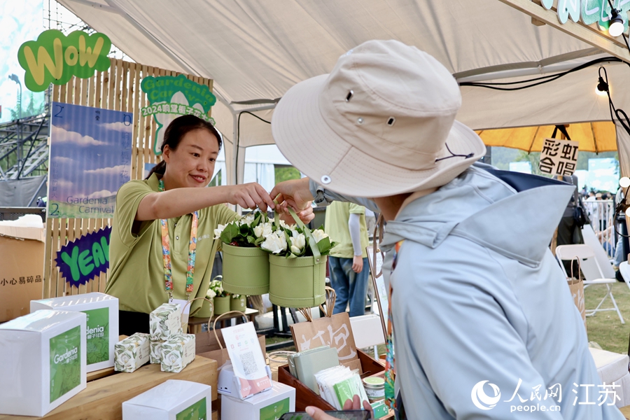 游客在潮玩市集購(gòu)買梔子花。人民網(wǎng) 王丹丹攝